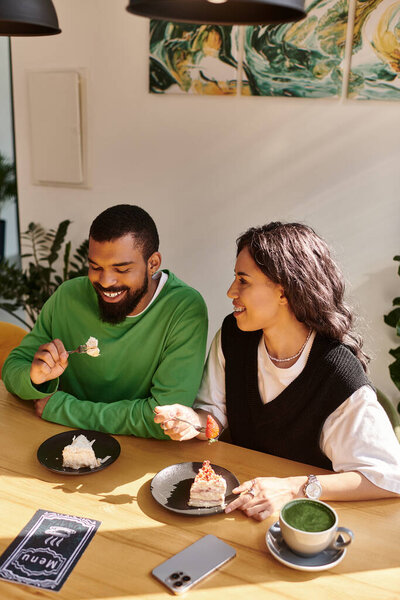 Афроамериканская пара делится радостным разговором и вкусными десертами в причудливом кафе.