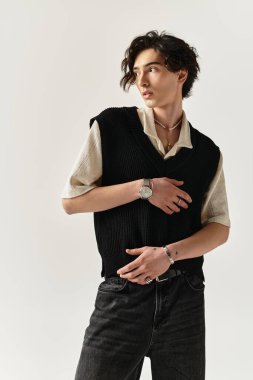 Şık genç adam, çağdaş eğilimleri vurgulayarak minimalist bir stüdyoda kendine güvenerek poz veriyor..