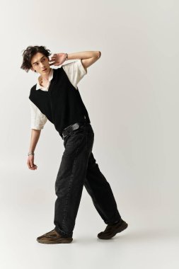 Yakışıklı bir genç adam şık bir elbiseyle poz veriyor, evin içinde kendine güveni ve cazibesi var..