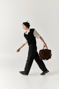 Yakışıklı genç bir adam modern modaya uygun, şık bir kıyafetle rahatça yürür..