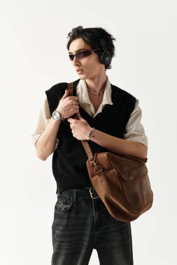 Yakışıklı bir genç, moda kıyafetlerini yaratıcı bir stüdyoda poz verirken sergiliyor..