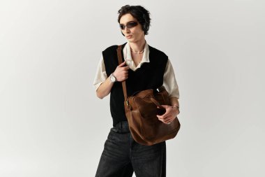Moda kıyafetli yakışıklı bir genç, kendine güvenerek stüdyoda şık görünümünü sergiliyor..