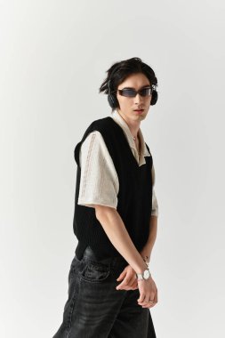 Şık bir takım elbise giyen bir adam, kendine güvenen bir şekilde şık bir stüdyo arka planında poz verir..