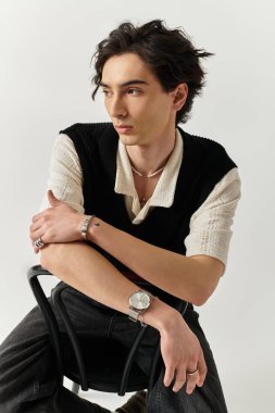 Yakışıklı bir genç, kendine güvenen bir şekilde şık bir şekilde poz verir..