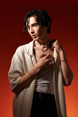 Cılız genç adam, cesur bir arka plana karşı poz verirken şık bir yaz kıyafeti modelliyor..