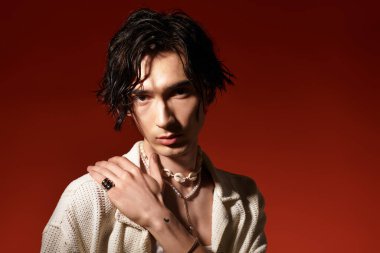 Genç bir adam sıcak bir zemine karşı yaz kıyafetiyle güven ve tarz yayar..