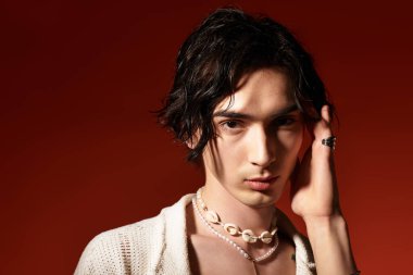 Sıska bir genç, dinamik bir stüdyo arka planında son moda bir yaz kıyafeti sergiliyor..