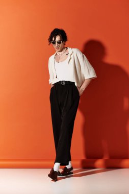 Sıska genç adam, canlı bir arka planda moda ileri görüşlü yaz görüntüsünü sergiliyor..