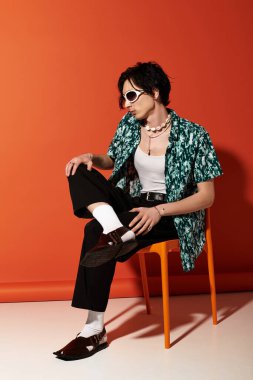 Genç adam şık bir şekilde şık bir yaz elbisesi içinde cesur bir arka plana karşı duruyor..