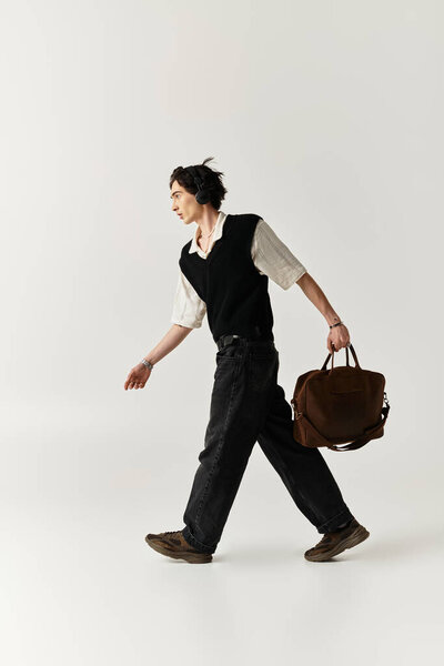 Красивый молодой человек уверенно ходит в стильном наряде, демонстрируя современную моду.