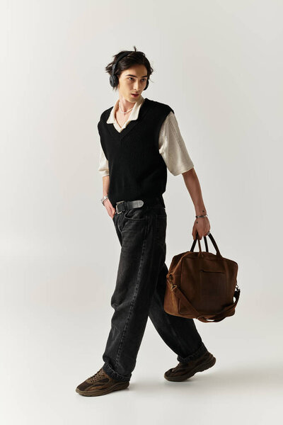 Красивый молодой человек уверенно ходит в стильном наряде в современной студии.