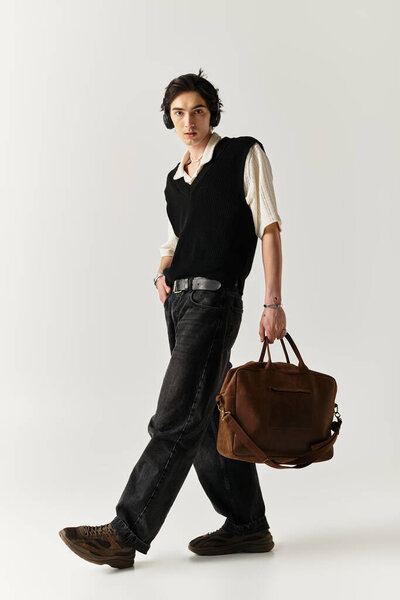 Уверенный в себе молодой человек демонстрирует свой модный наряд на минималистическом фоне.