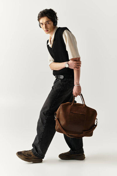 Стильный молодой человек уверенно позирует в гладкой студии, демонстрируя свое чувство стиля.