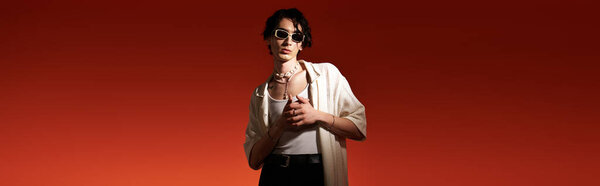 Young man poses confidently in a trendy summer outfit against a vibrant backdrop, banner