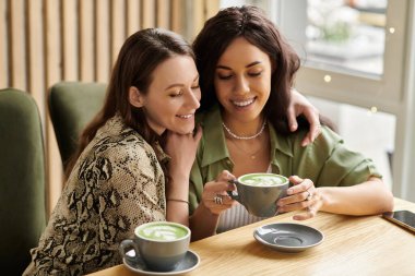 İki kadın, yeşil çay içerken tuhaf bir kafede kahkaha ve iletişimi paylaşıyor..