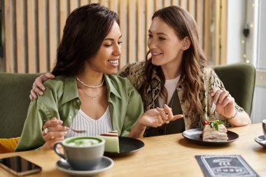 İki kadın, büyüleyici bir kafede tatlı ve içkinin tadını çıkarırken birbirlerine eşlik etmekten zevk alırlar..