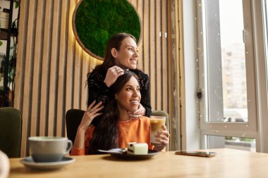 Mutlu bir çift, büyüleyici bir kafede birbirlerine eşlik etmekten zevk alır, kahkahalarını ve sevgilerini paylaşırlar..