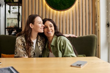 İki kadın, büyüleyici bir kafede mutlu mesut eğleniyor. Sevgi ve sıcaklık saçıyorlar..