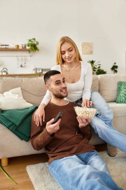 Sevgi dolu çift evde gevşeyip, en sevdikleri programı izlerken patlamış mısır ve neşe paylaşıyor..
