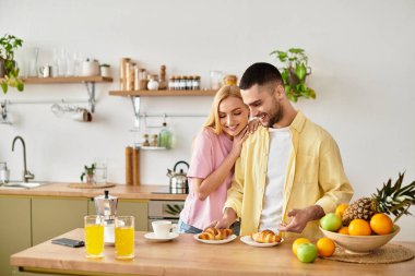Sevgi dolu bir çift kahvaltıdan zevk alır, kahkaha atar ve sıcak mutfaklarında tatlı anlar paylaşır..