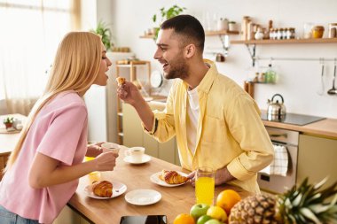 Neşeli aşıklar keyifli bir sabah yemeğini paylaşır, birbirlerini canlı dekorların arasında hamur işleriyle besler.