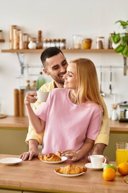 Bir çift, sıcak mutfaklarında sevgi ve sıcaklığı kucaklayarak keyifli bir kahvaltı deneyimi yaşıyor..