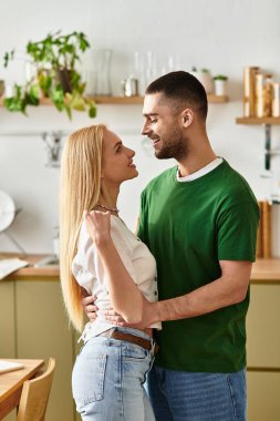 Sevgi dolu çift, sıcak ve davetkar bir mutfak ortamında samimi bir kucaklaşmayı paylaşıyor..