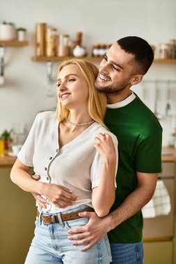 Çiftler, modern mutfaklarında yemek pişirirken birbirlerine sevgi ve mutluluk saçıyorlar..