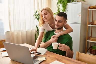 Bir çift evde dizüstü bilgisayar kullanırken sevgiyi ve sıcaklığı paylaşıyor..