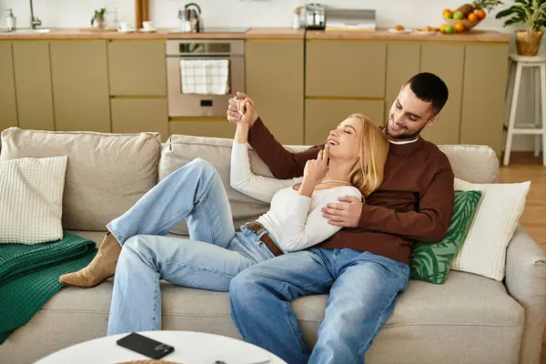 Sıcak kalpli çift rahat bir kanepede rahatlar. Aşklarını ve neşelerini kutlarlar..