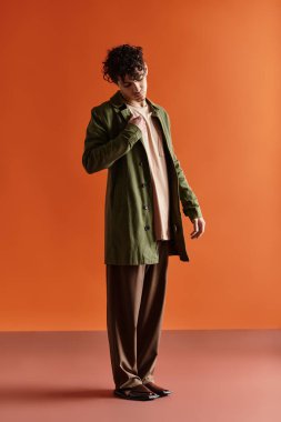 Yakışıklı, şık giyinmiş genç adam kendine güvenerek duruyor, aynı zamanda cazibe ve zarafet saçıyor..