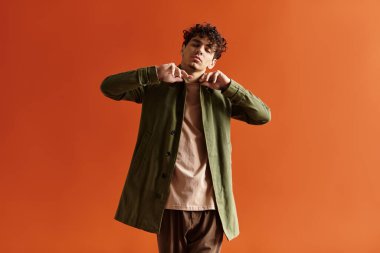 Genç adam kendine güvenerek şık kıyafetini sergiliyor, büyüleyici bir poz veriyor..