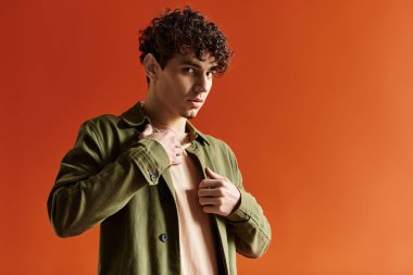 Şık bir genç adam ceketini cesur bir ortamda düzeltirken alımlı görünüşünü sergiliyor..