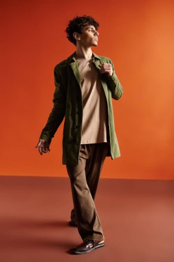 Yakışıklı, modaya uygun giyinmiş genç bir adam sıcak bir atmosferde şık bir atmosferi olan yürüyüşler yapıyor..