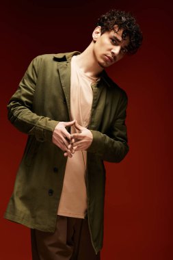 Çekici adam rahat duruşu ve etkileyici el hareketleriyle şık kıyafetler sergiliyor..