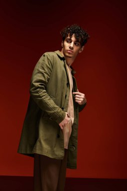 Yakışıklı genç adam şık bir moda sergiliyor. Çarpıcı kırmızı bir duruşu var..