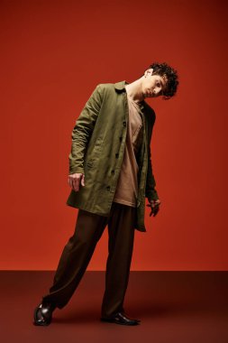 Şık bir genç adam kendine güvenen bir pozla moda anlayışını sergiliyor..
