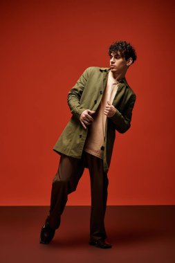 Yakışıklı genç adam kendine güvenerek poz veriyor. Şık bir elbisenin altını çiziyor..