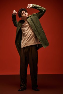 Yakışıklı bir genç adam kendine güvenerek modern modanın özünü yakalıyor..