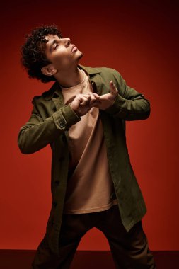 Yakışıklı genç adam sanatsal bir duruş sergiliyor, kendine has tarzını enerjik bir atmosferde sergiliyor..