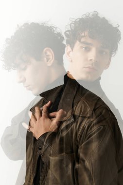 Şık bir genç adam kendine güvenen, yaratıcı bir kompozisyonda modern yeteneğini sergiliyor..