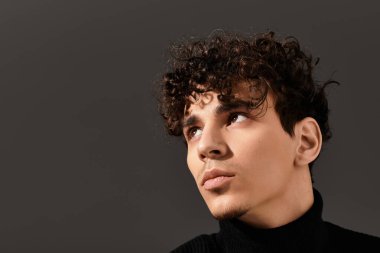 Büyüleyici genç adam, zarif kıvırcık saçlarıyla özgüvenini sergiliyor..