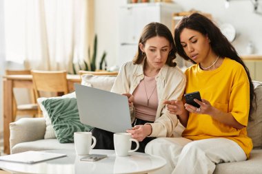 Parlak bir oturma odasında birlikte oturan iki kadın, mutlu anlarını paylaşıyorlar..
