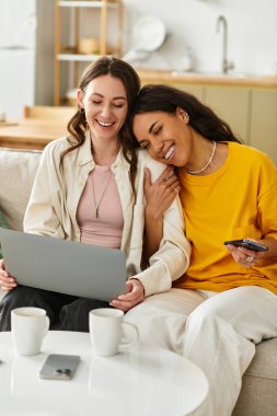 İki kadın, evlerinde sevgi ve sıcaklık saçan bir dizüstü bilgisayar kullanırken birbirlerine eşlik etmekten zevk alırlar..