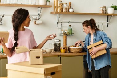 İki kadın, mutfaklarındaki kutuları açarken aynı güzel anları paylaşıyorlar..