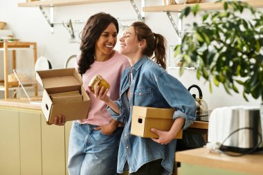 İki kadın, kutularını açarken ve evde birbirlerine eşlik ederken hassas bir anı paylaşıyor..