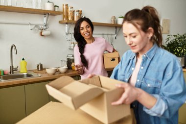 İki kadın yeni evlerini mutlulukla düzenliyor, mutfakta gülüşmeler ve aşk paylaşıyorlar..