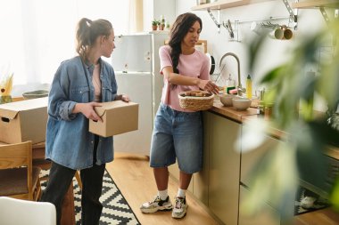 İki neşeli kadın, sevgi ve kahkahalarla dolu mutfaklarında bavullarını boşaltıp anlarını paylaşıyorlar..