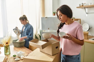 İki kadın mutlulukla ortak yaşam alanlarında kutuları açıyor, sevgi ve sıcaklığı kucaklıyorlar..