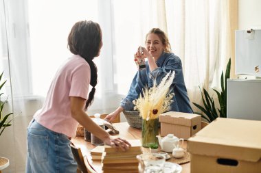 İki kadın sıcak evlerinde kutuları açarken keyifli bir anın tadını çıkarırlar..